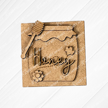 The Bee Swappable Squares DIY kit by Janet's Craft Corner includes the honey jar labeled "Honey,"  - displayed on a white wood background.