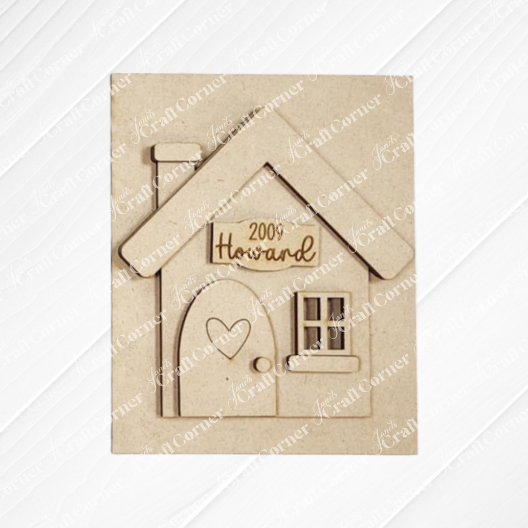 Janet's Craft Corner offers a House Interchangeable Farmhouse Sign, a DIY home decor craft kit with engraved details. Personalize it with your family name and year established, featuring a heart-adorned door and window, perfect for home decor enthusiasts.
