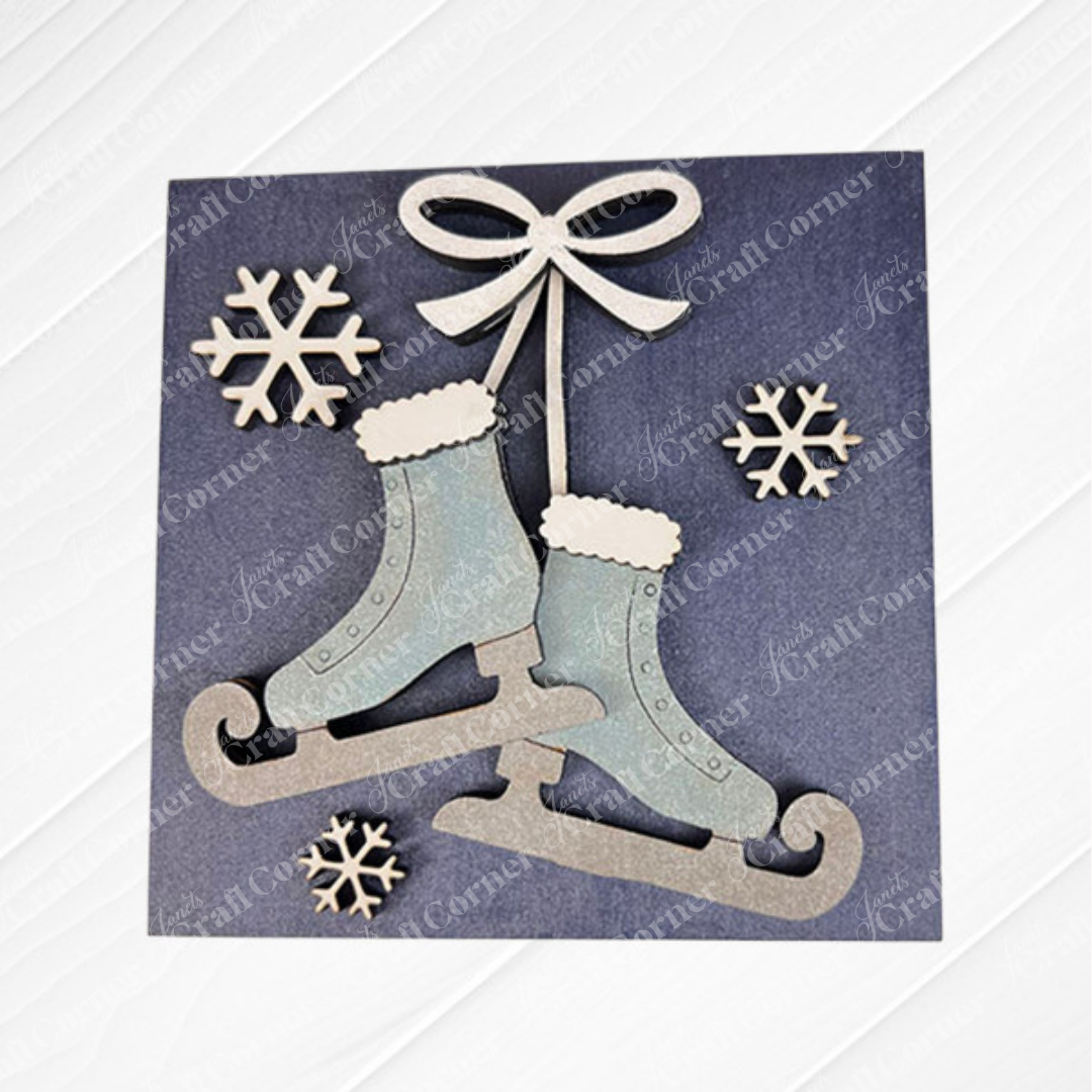 Hello Winter Squares" by Janet's Craft Corner features two light blue ice skates with white cuffs, tied with a bow and surrounded by snowflakes on a dark background—ideal wintry décor for your home or tiered tray.