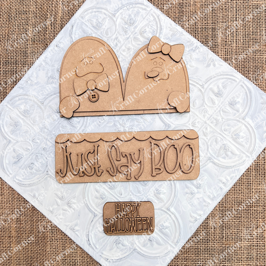 The Just Say Boo Interchangeable Insert by Janet's Craft Corner includes 3 unfinished wood pieces—ghost cutouts with bows, buttons, and Halloween signs—perfect for DIY seasonal home decor.