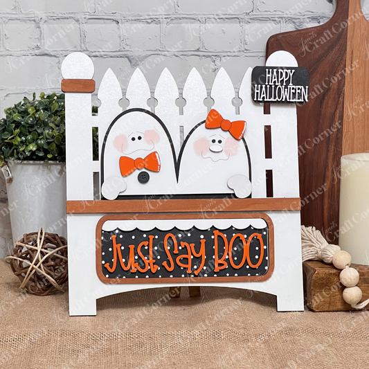Janet's Craft Corner's Just Say Boo Interchangeable Insert craft kit includes two ghost with orange bows and signs that say "Just Say Boo" and "Happy Halloween"—perfect DIY Halloween decor or insert for your home, featuring three cute pieces displayed on a white garden fence base.