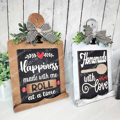 Janet's Craft Corner Kitchen Switchable Farmhouse Signs DIY kit lets you create rustic kitchen decor—one sign reads "Happiness made with one roll at a time," the other, "Homemade with love" (with spoon and hearts). Set of 1 included.