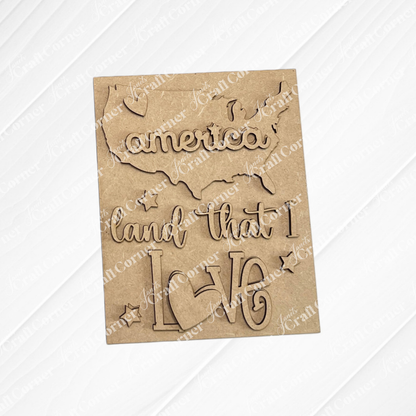 The Patriotic Farmhouse Signs DIY kit by Janet's Craft Corner features a wooden USA cutout with “america,” “land that I,” and “love” scripts, stars, and a heart—perfect for tiered trays or as switchable seasonal farmhouse decor.
