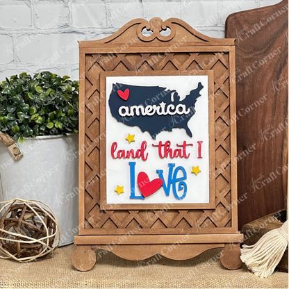 Janet's Craft Corner Patriotic Farmhouse Sign DIY kit features a U.S. map cutout with a red heart and "america land that I Love" in colorful letters—perfect as seasonal decor for your tiered trays, stands, or farmhouse displays.