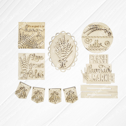 The Lavender Decor Set by Janet's Craft Corner features laser-cut wooden pieces for DIY home decor, including pinecones, leaves, and phrases like “Hello” and “Love grows here.” Includes banners and plaques—perfect unfinished wood craft kit.