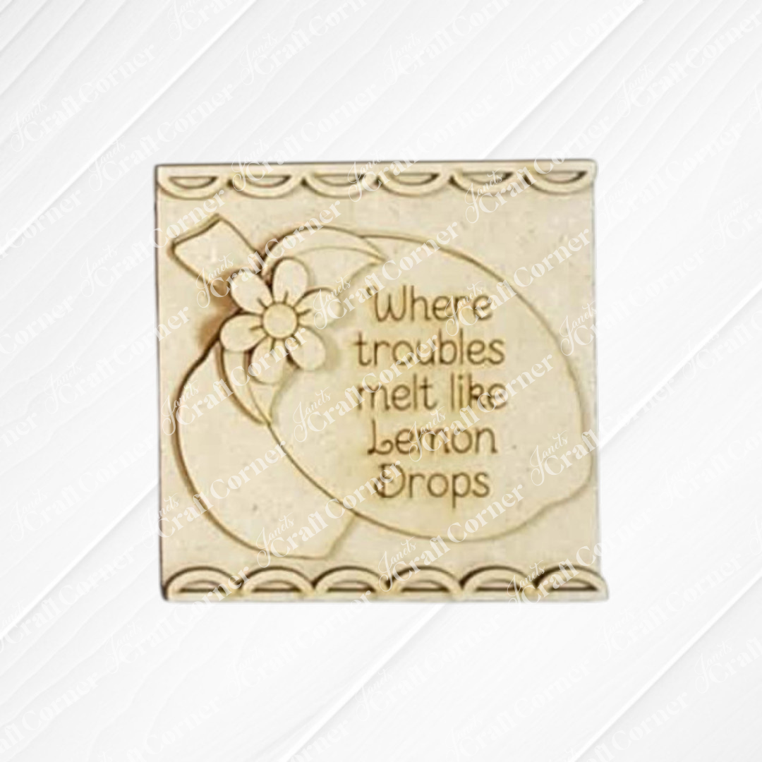 Janet's Craft Corner Lemon Squares is a beige decorative plaque with lemons and flowers, reading "Where troubles melt like lemon drops." Part of our Swappable Squares DIY decor, it has a scalloped border for easy crafting.