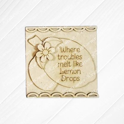 Janet's Craft Corner Lemon Squares is a beige decorative plaque with lemons and flowers, reading "Where troubles melt like lemon drops." Part of our Swappable Squares DIY decor, it has a scalloped border for easy crafting.