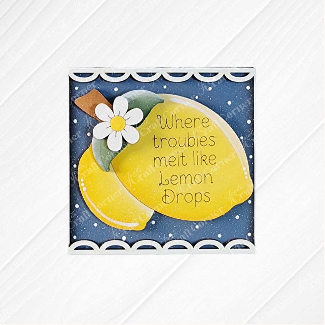 Janet’s Craft Corner’s Lemon Squares is a framed sign featuring a painted lemon and white flower on blue with “Where troubles melt like lemon drops,” Swappable Squares, a scalloped white border, and textured surface—perfect seasonal DIY home decor.