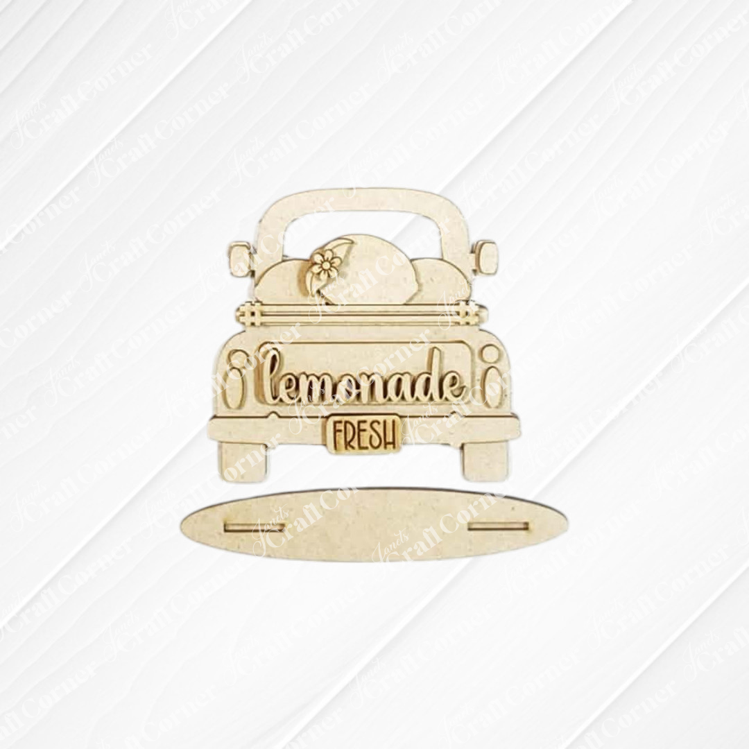 The Lemon Decor Set by Janet's Craft Corner features an unfinished wooden vintage truck cutout with "lemonade," a "fresh" tailgate sign, lemon slice accents, and a separate oval base—perfect for farmhouse décor.