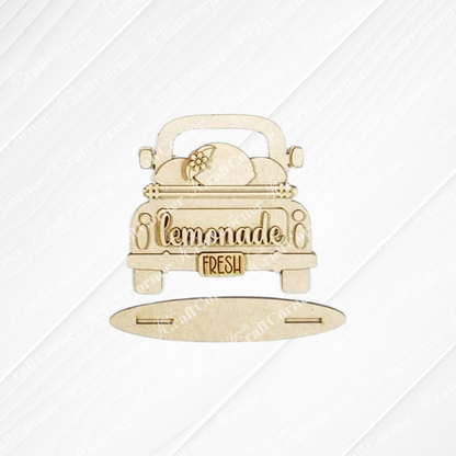 The Lemon Decor Set by Janet's Craft Corner features an unfinished wooden vintage truck cutout with "lemonade," a "fresh" tailgate sign, lemon slice accents, and a separate oval base—perfect for farmhouse décor.