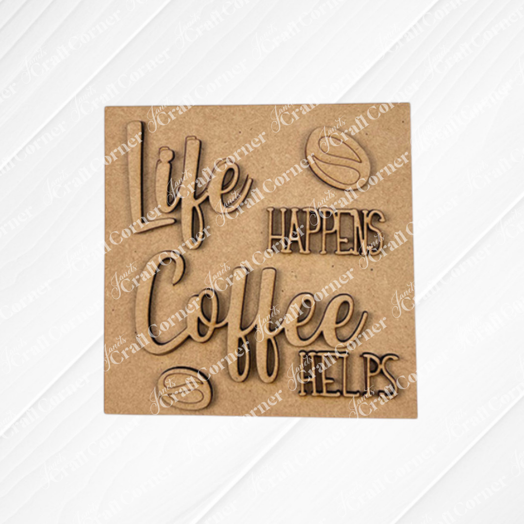 A wooden sign on a textured white background reads “Life happens, coffee helps,” surrounded by coffee bean designs—the perfect inspiration for your next Coffee Swappable Squares DIY kit from Janet's Craft Corner.