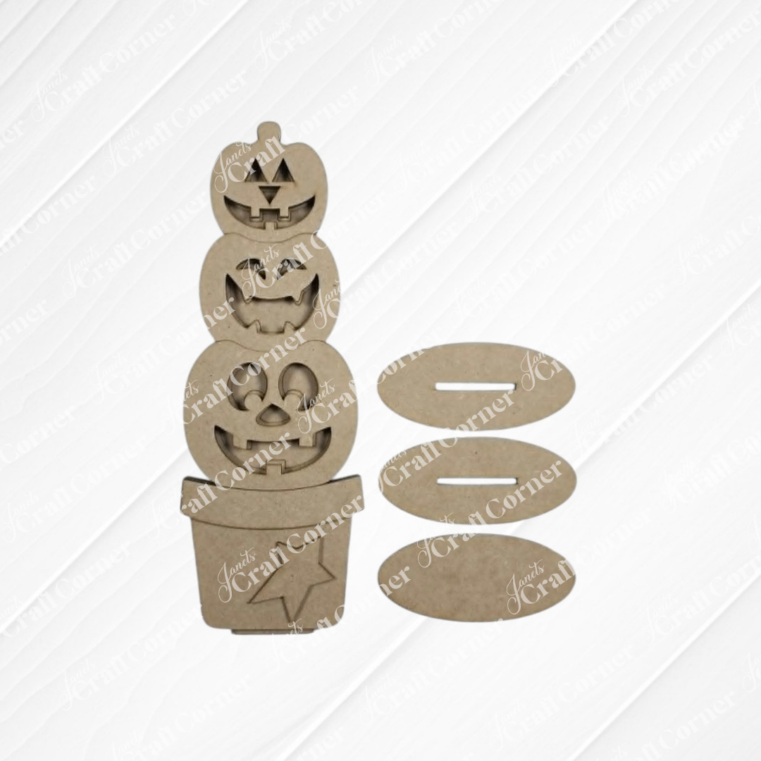 Create your own unique fall and Halloween decor with Janet’s Craft Corner Light-up Stacking Pumpkin Shelf Sitter DIY home decor craft kit, set of 1, available in your choice of two sizes—featuring unpainted MDF pieces shaped like three stacked jack-o’-lanterns in a pot with four oval stands, all arranged on a white textured surface.