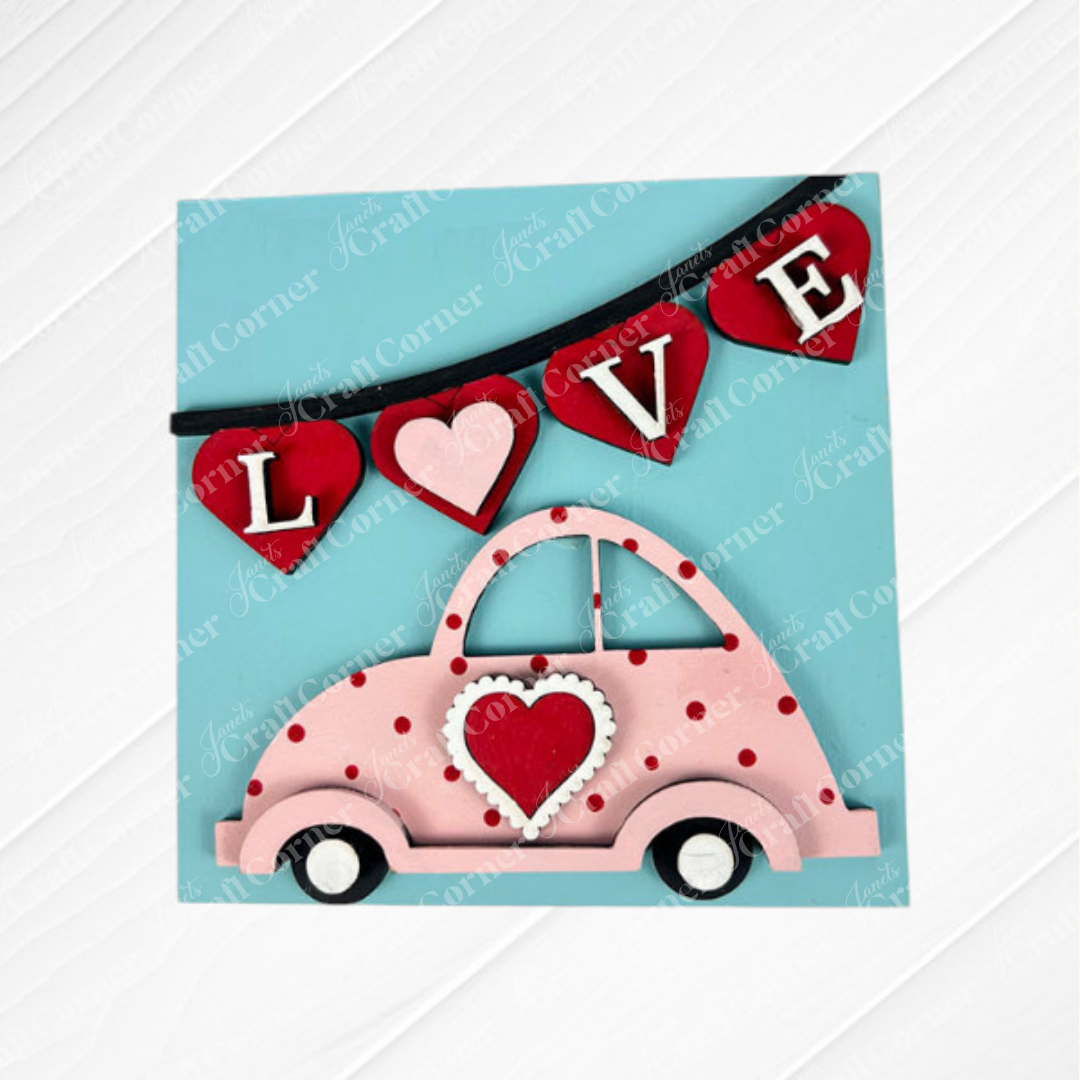 Valentine Squares by Janet's Craft Corner feature a pink car with a heart on its door under a red "LOVE" heart banner on light blue—a playful, romantic accent for tiered trays or DIY seasonal home decor.