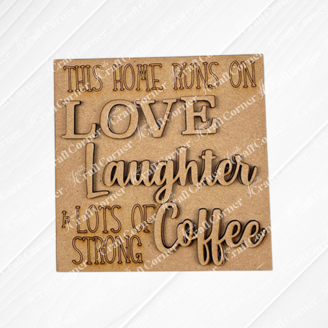 The Coffee Bar Swappable Squares DIY kit from Janet's Craft Corner features a wooden sign with engraved text: "This home runs on love, laughter & lots of strong coffee," ideal for seasonal home decor with a cozy, coffee-inspired touch.