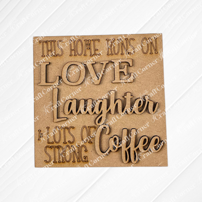The Coffee Bar Swappable Squares DIY kit from Janet's Craft Corner features a wooden sign with engraved text: "This home runs on love, laughter & lots of strong coffee," ideal for seasonal home decor with a cozy, coffee-inspired touch.
