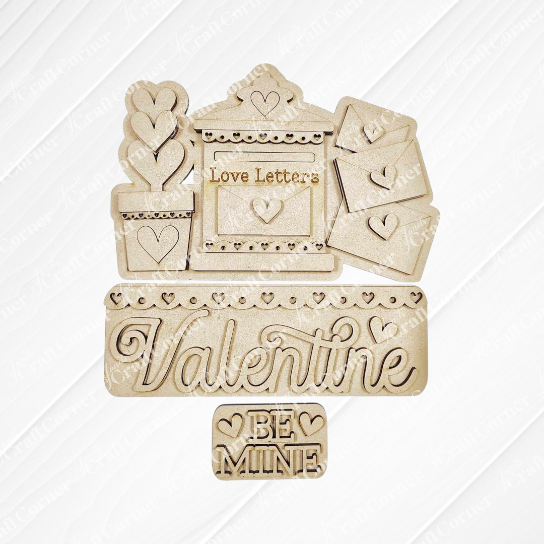 Janet's Craft Corner presents the Love Letters Interchangeable Insert: hand-painted wooden Valentine's cutouts including a "Love Letters" mail slot, a "Valentine" sign, and a "Be Mine" plaque with heart details on burlap over a textured white background.