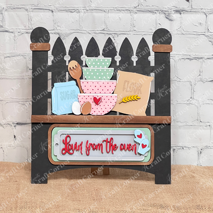 The Lovin from the Oven Interchangeable Insert by Janet's Craft Corner is a DIY home decor craft kit featuring a mini oven wooden sign with "Love from the oven" in red cursive, baking item cutouts, and a brick backdrop—perfect for home décor enthusiasts to add charm and creativity.