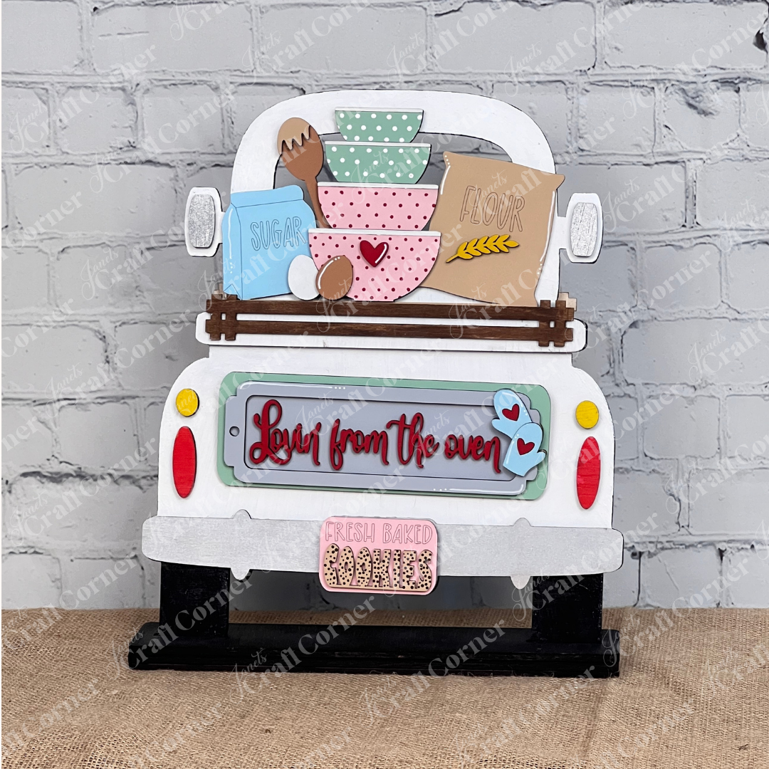 Janet's Craft Corner offers the "Lovin from the Oven" Interchangeable Insert, part of a DIY home decor craft kit. This set of 3 pieces features a decorative truck cutout with bowls labeled "sugar" and "flour," eggs, and wheat on a stand against a white brick wall, with text saying "Love from the oven" and "Fresh baked cookies.