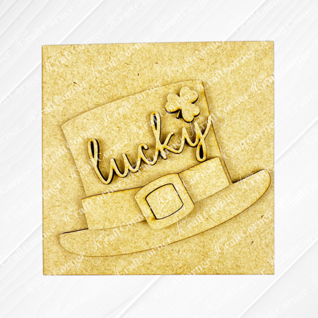 The Lucky Irish Squares by Janet's Craft Corner feature a wooden leprechaun hat cutout with "lucky" and a four-leaf clover, ideal for tiered tray decor, shown on a light textured background.