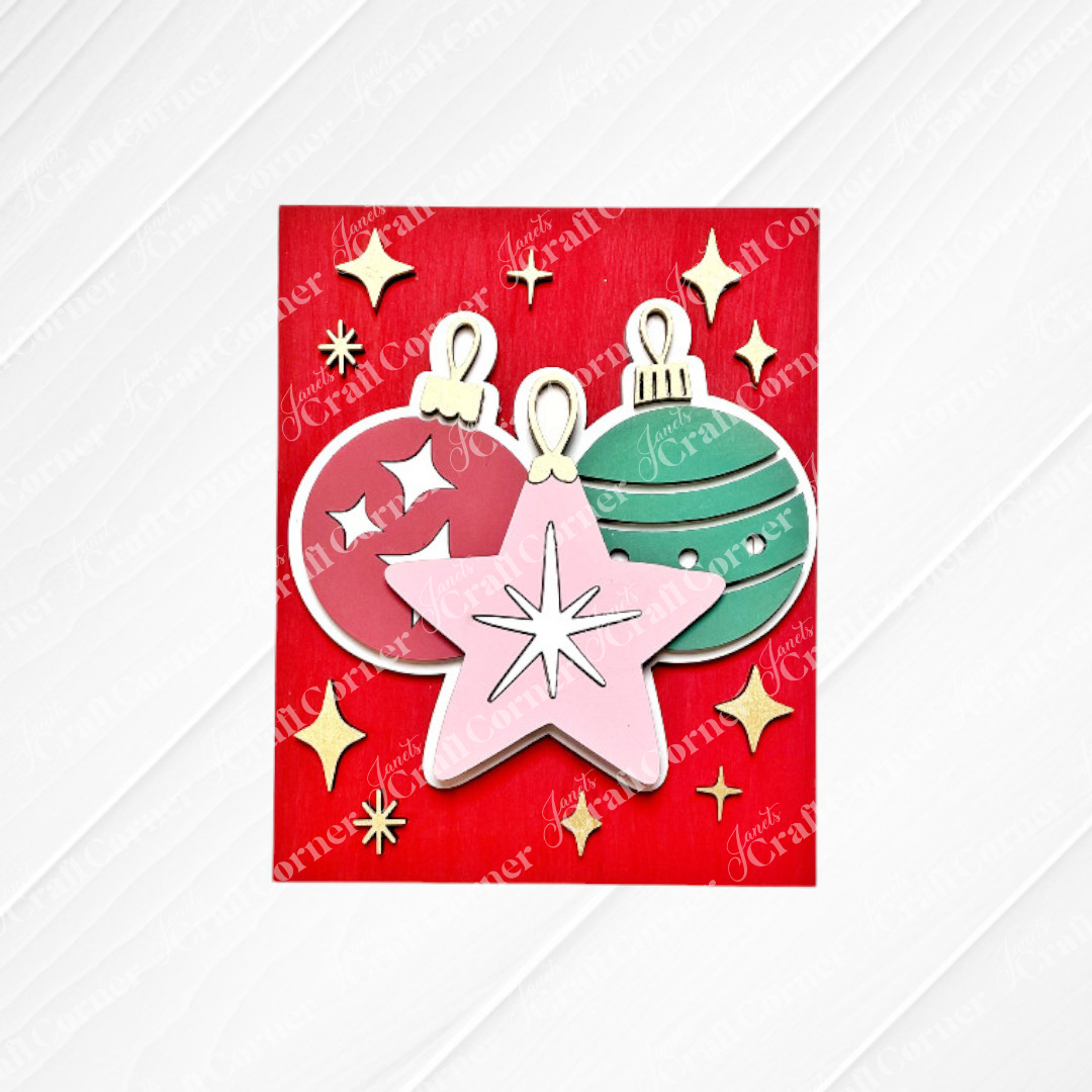 Janet's Craft Corner's Merry Midcentury Modern Switchable Farmhouse Sign features three festive ornaments on a red background—perfect as seasonal DIY home décor or paired with other craft kits this holiday season.