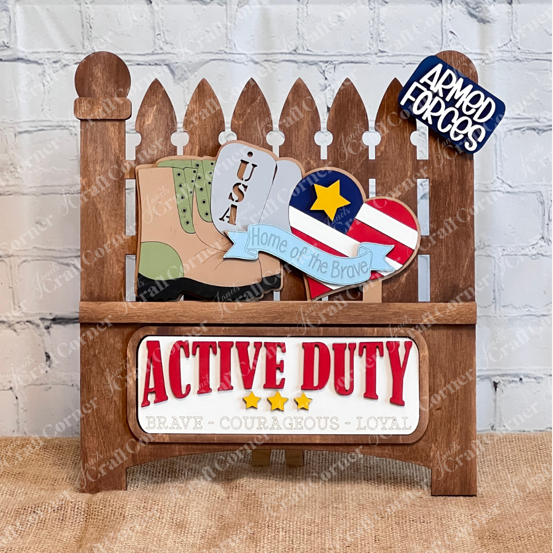 Janet's Craft Corner offers a Military Interchangeable Insert DIY kit, featuring USA-themed wooden cutouts like boots and a heart-shaped flag with "Active Duty" and "Brave - Courageous - Loyal" designs. It includes signs like "Home of the Brave," perfect for DIY enthusiasts.