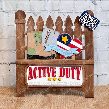 Janet's Craft Corner offers a Military Interchangeable Insert DIY kit, featuring USA-themed wooden cutouts like boots and a heart-shaped flag with "Active Duty" and "Brave - Courageous - Loyal" designs. It includes signs like "Home of the Brave," perfect for DIY enthusiasts.