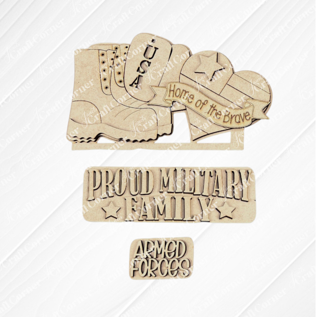 Janet's Craft Corner presents the Military Interchangeable Insert, a DIY home decor kit featuring wooden military-themed cutouts on a white textured square. The designs include a boot, dog tags, and a helmet inscribed with "USA" and "Home of the Brave." Additionally, it features text like "Proud Military Family" and "Armed Forces," all set against a patriotic burlap background.