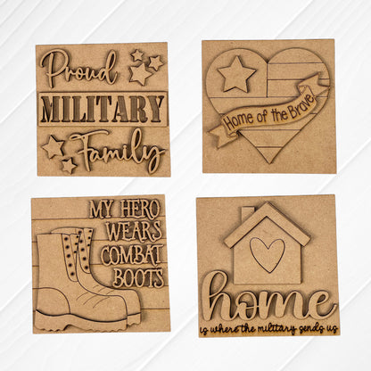 Janet's Craft Corner Military Squares are four wood plaques with engraved, cutout designs: “Proud Military Family,” a heart with “Home of the Brave,” combat boots, and a house, perfect for tiered tray décor.