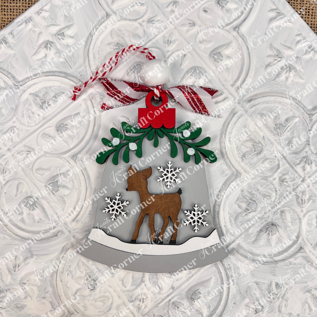 Janet's Craft Corner Mistletoe Ornaments DIY Decor Kit (Set of 6) lets you create festive ornaments with reindeer, green leaves, red bows, snowflakes, and ribbons—perfect for holiday decor against a textured white background.