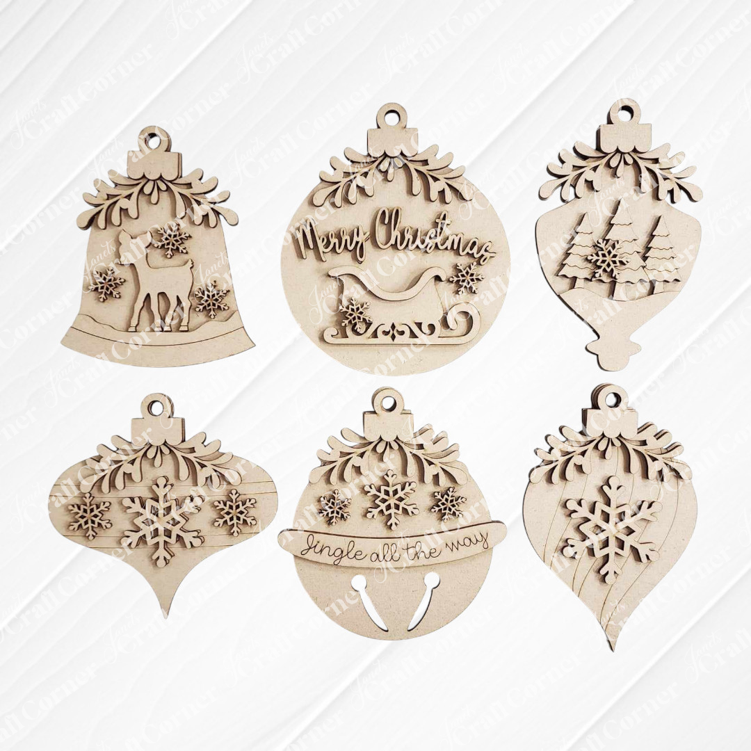 The Mistletoe Ornaments DIY Decor Kit by Janet's Craft Corner features six festive wooden ornaments—reindeer, sleigh, trees, snowflakes, and “Jingle all the way”—perfect for charming holiday decor or crafting fun.