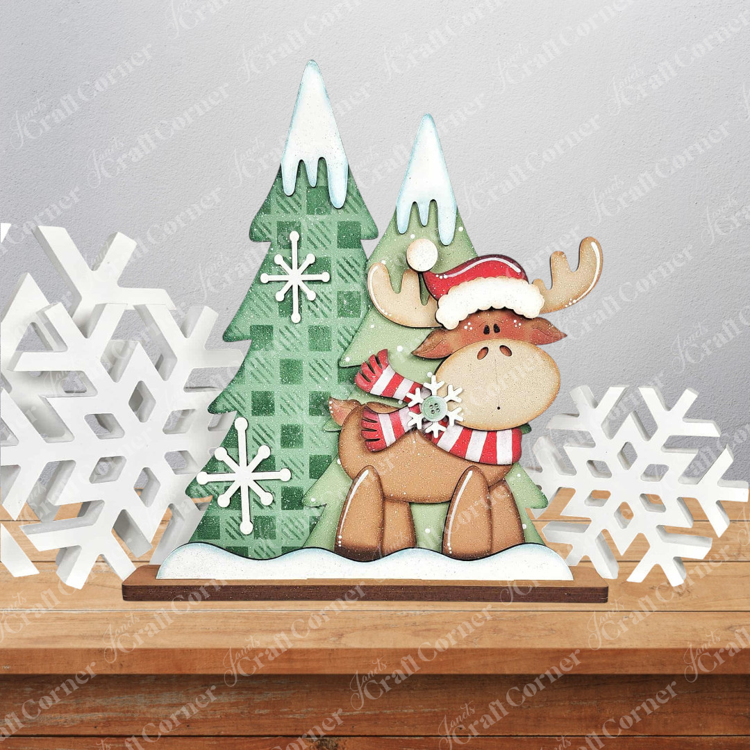 Create a charming woodland scene with Janet's Craft Corner "Moose with Trees Shelf Sitter" DIY kit, featuring a festive moose in a Santa hat and scarf among pine trees and snowflakes—perfect seasonal home decor!.