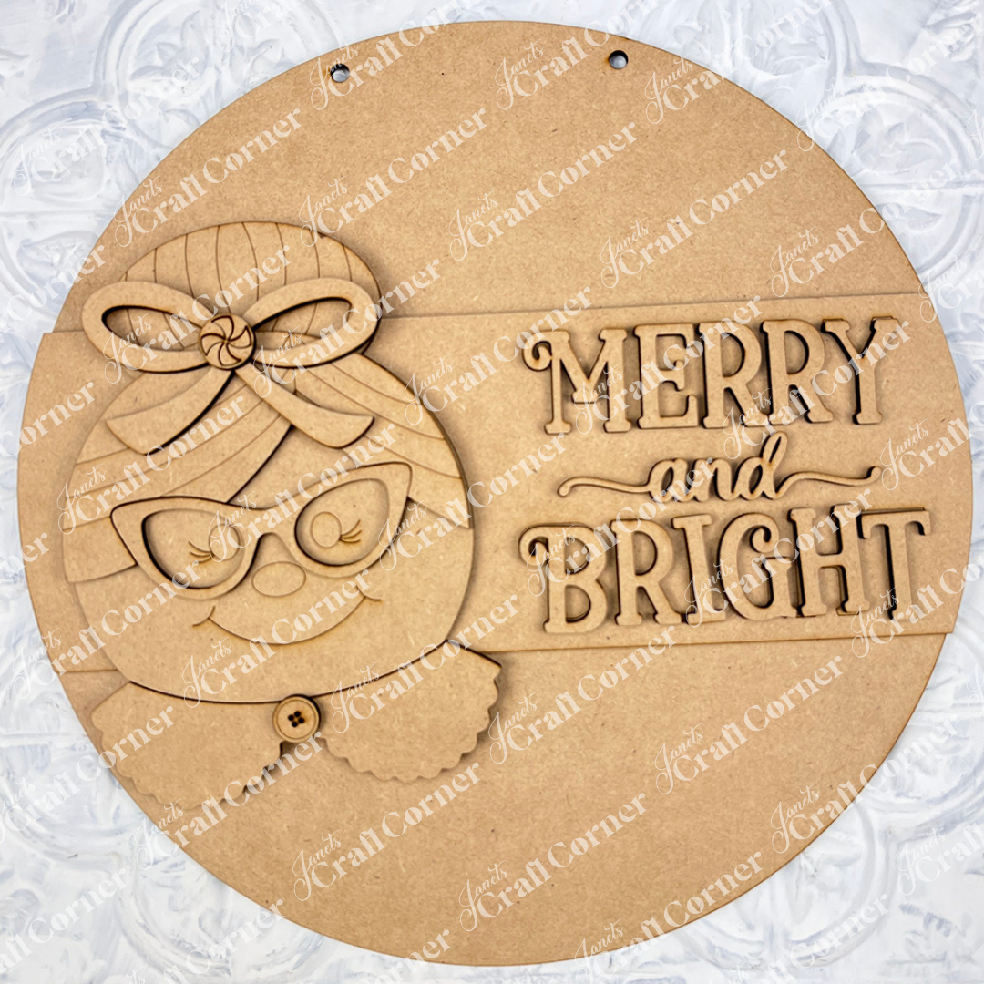 Janet's Craft Corner Mrs. Claus Merry & Bright Round Sign is a DIY seasonal home decor craft kit featuring a smiling snowman face with glasses and bow, textured background, “Merry & Bright” text, and holes for hanging. Set of 1.