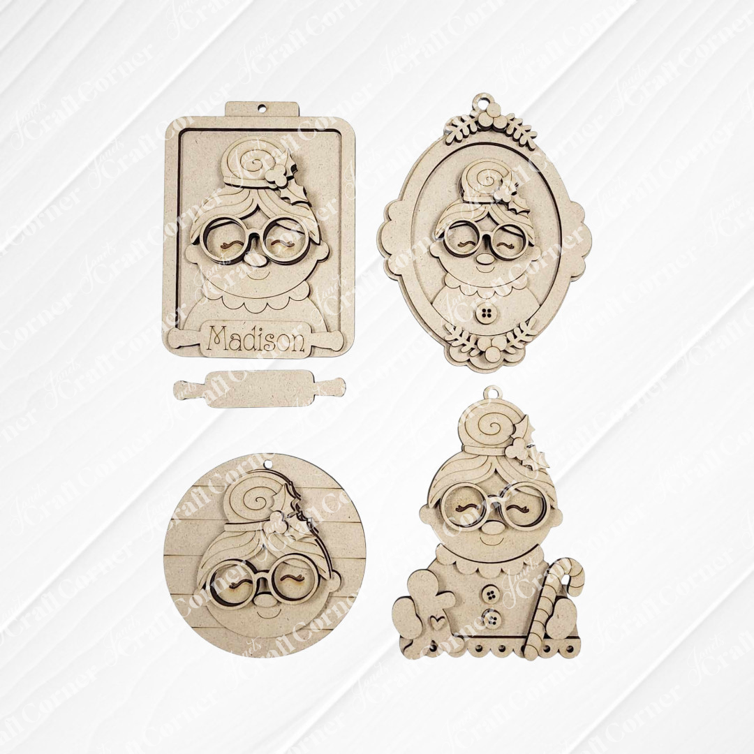Set of four Mrs. Claus Ornaments from Janet's Craft Corner, each with glasses and a bun in assorted shapes (clipboard, oval frame, circle, candy cane stand). Ideal for festive decor or DIY crafts. One ornament labeled "Madison.