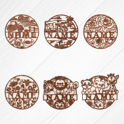 Janet's Craft Corner Nursery Name Wall Hanger set includes six unfinished round wood plaques in truck, bulldozer, floral, wildflowers, woodland, and zoo animal designs. Each has a customizable "NAME" space—ideal for DIY nursery decor.