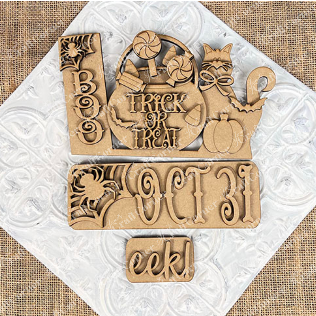 Introducing the Oct 31 Interchangeable Insert DIY home decor kit from Janet's Craft Corner: a delightful set of hand-painted wooden Halloween decorations that look stunning on a white embossed surface. This kit includes carved words such as "Boo," "Oct 31," and "eek," as well as charming figures like a cat, pumpkin, candies, and an interchangeable sign with “Trick or Treat” on a burlap background—ideal for creating personalized and festive decor in your home.