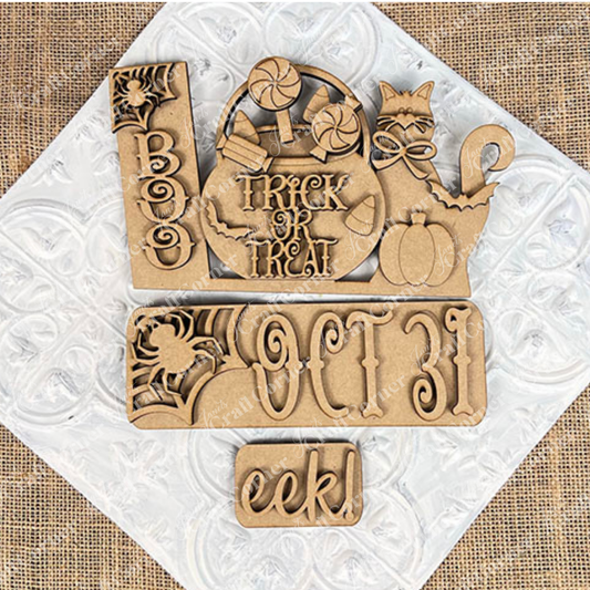 Introducing the Oct 31 Interchangeable Insert DIY home decor kit from Janet's Craft Corner: a delightful set of hand-painted wooden Halloween decorations that look stunning on a white embossed surface. This kit includes carved words such as "Boo," "Oct 31," and "eek," as well as charming figures like a cat, pumpkin, candies, and an interchangeable sign with “Trick or Treat” on a burlap background—ideal for creating personalized and festive decor in your home.