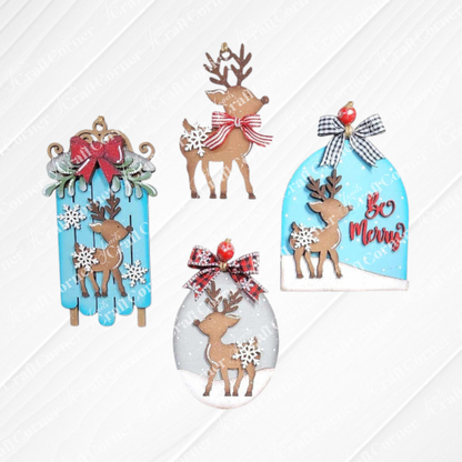 The Oh Deer Ornament Set from Janet's Craft Corner includes four Christmas ornaments on a white wood background. Each piece showcases a reindeer silhouette surrounded by snowflakes and bows, set against unique backgrounds: sled, oval, circle, and bell shapes with the phrase "Be Merry." This DIY Craft Kit provides hand-painted home décor in a palette of brown, red, blue, and white tones.
