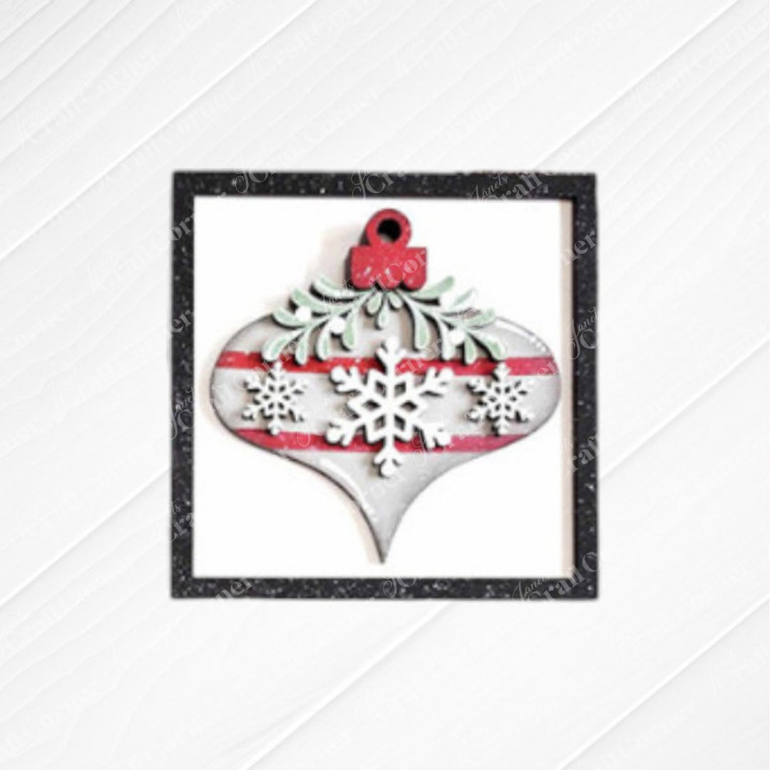 Janet's Craft Corner Mistletoe Swappable Squares DIY kit features a wood cut-out ornament with red stripes, white snowflakes, and green foliage in a black glitter square—ideal for tiered trays or holiday decor. Choice of 4 designs!.