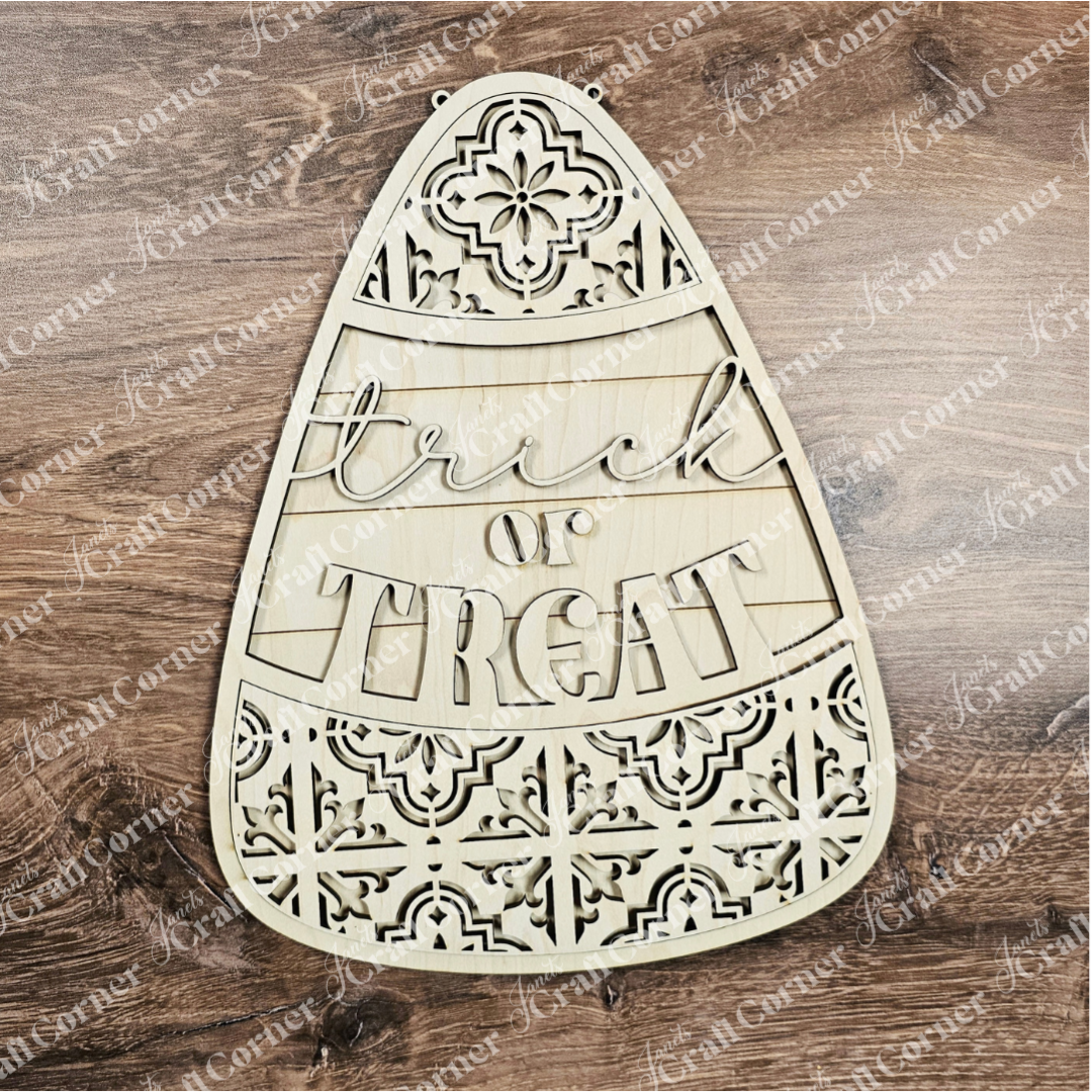 Wooden candy corn-shaped decoration with 'Trick or Treat' text on a wooden background
