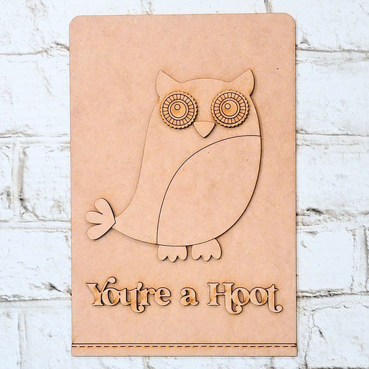 The "You're a Hoot" Tea Towel from Janet's Craft Corner is a delightful DIY home decor kit that features a carved owl illustration alongside the engraved text "You're a Hoot." Perfect for adding rustic charm to your space, this tea towel can be beautifully displayed against a textured white brick wall for those who love unique craft projects.