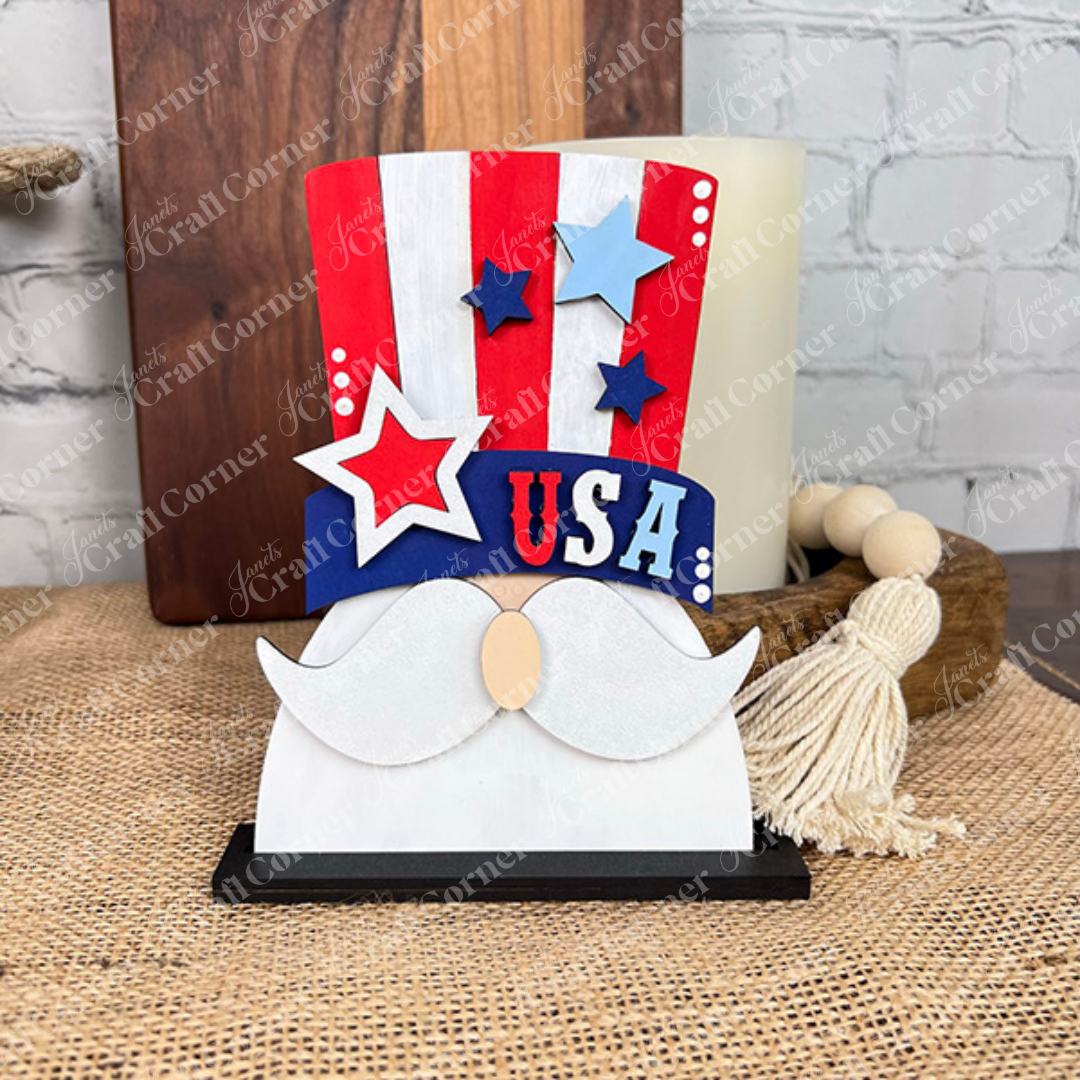 Janet's Craft Corner Patriotic Mini Shelf Sitters DIY Craft Kit features mustache and Uncle Sam’s hat shapes with red, white, and blue stripes, stars, and "USA"—perfect Americana décor for your shelf or table.