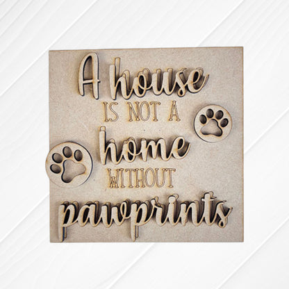 Janet's Craft Corner Dog Squares: Wooden sign featuring engraved and cut-out "A house is not a home without pawprints" text with two paw prints on light wood—ideal for tiered tray decor or pairing with other wood cut-outs.