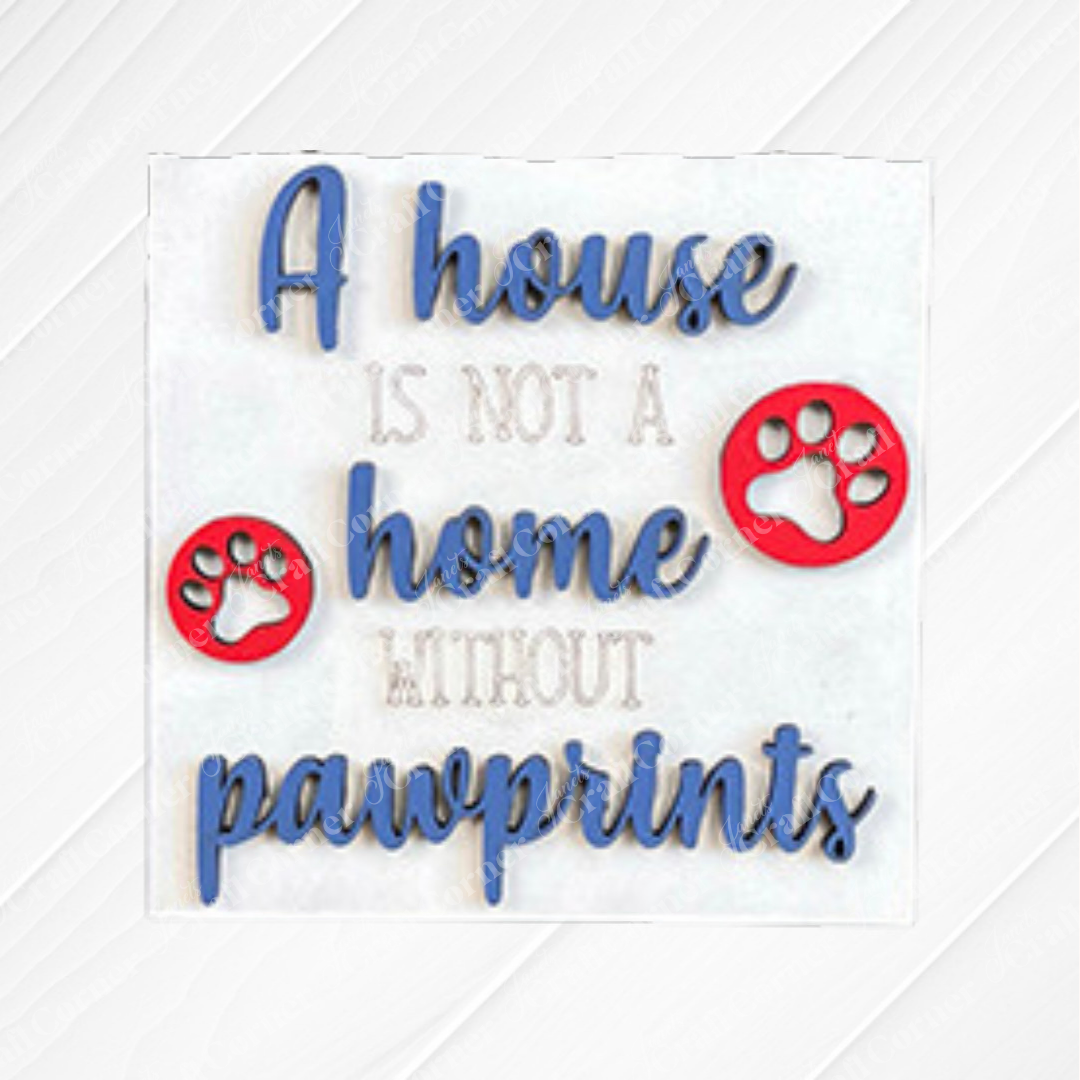 Dog Squares by Janet's Craft Corner is a decorative sign with "A house is not a home without pawprints" in blue and gray, two red paw prints, and a textured background—ideal for tiered tray decor or pairing with wood cut-outs.