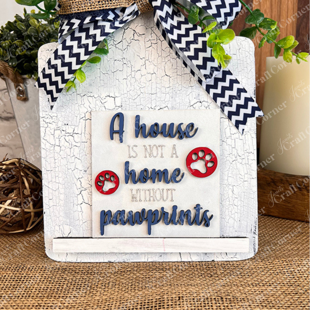 Dog Squares by Janet's Craft Corner features two paw prints and "A house is not a home without pawprints," accented with a chevron bow and rustic touches—ideal for tiered tray decor or pairing with other wood cut-outs.