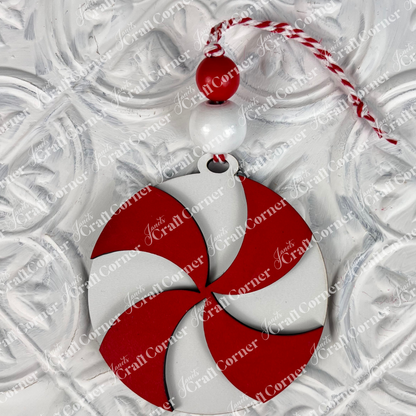 Introducing the Round Christmas Ornaments from Janet's Craft Corner! These DIY Decoration Kits feature red and white swirled ornaments adorned with two beads and a red and white twisted string, all set against a textured white backdrop. Perfect for adding festive charm to your holiday decorations.