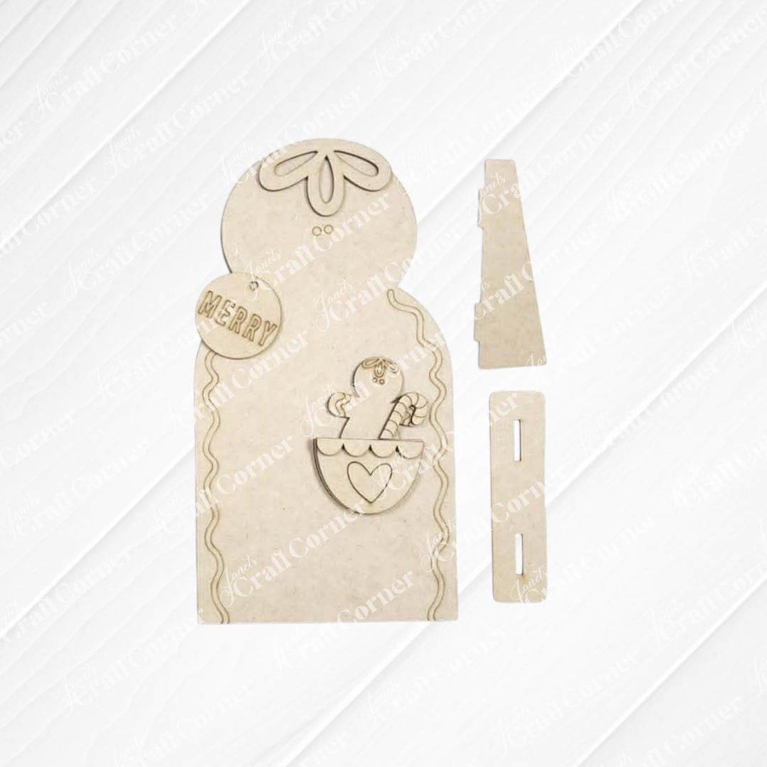 Introducing the Pocket Gingerbread Shelf Sitter DIY home decor craft kit from Janet’s Craft Corner—this unassembled set features charming wooden pieces, including a snowman with a hat, a “Merry” ornament, and a heart with holly. Designed for festive holiday decorating, each piece is slotted for easy assembly, making it perfect for creating your own delightful seasonal display. Set of 1.