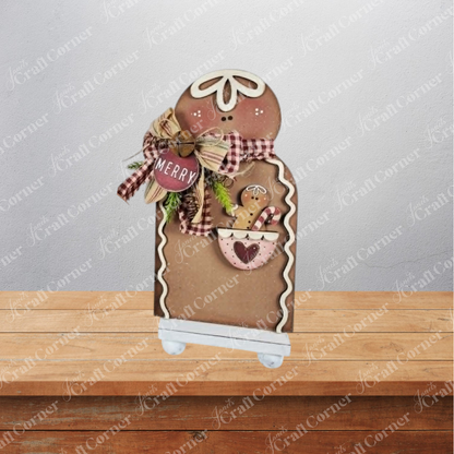 Add a touch of festive cheer to your home with the Pocket Gingerbread Shelf Sitter DIY home decor craft kit from Janet’s Craft Corner—this charming gingerbread-shaped wooden decoration, adorned with a bow, greenery, candy canes, and a “Merry” tag, stands on a small white base and is perfect as holiday shelf decor or as an adorable accent for any room.