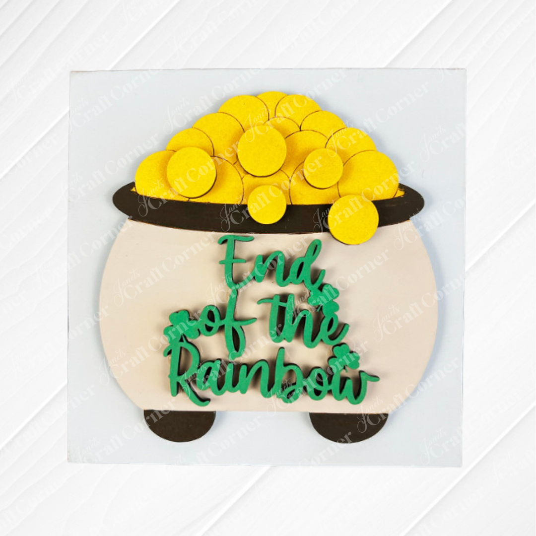The St Patricks Squares by Janet's Craft Corner is a decorative wood cut-out of a gold coin pot with "End of the Rainbow" in green text, set on a white diagonal-lined background—ideal tiered tray decor.