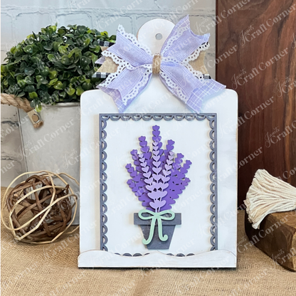 The Lavender Switchable Farmhouse Signs – DIY Craft Kit from Janet's Craft Corner features a white scalloped plaque with paper lavender, finished with a lace and burlap bow—ideal for tiered trays or rustic farmhouse décor.