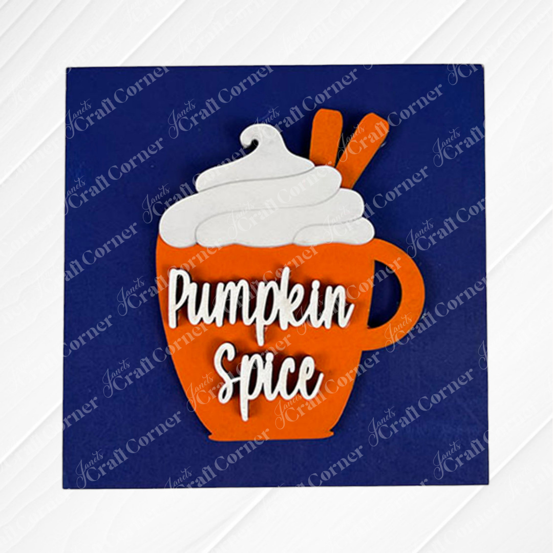 A bright orange "Pumpkin Spice Squares" cup by Janet's Craft Corner, topped with whipped cream and cinnamon sticks, stands out against a blue background—ideal for festive tiered tray displays or pairing with wood accents.